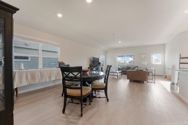 dining area featuring light hardwood / wood-style floors and lofted ceiling