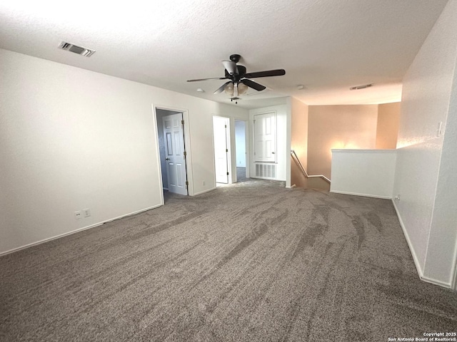 empty room with ceiling fan, dark carpet, and a textured ceiling