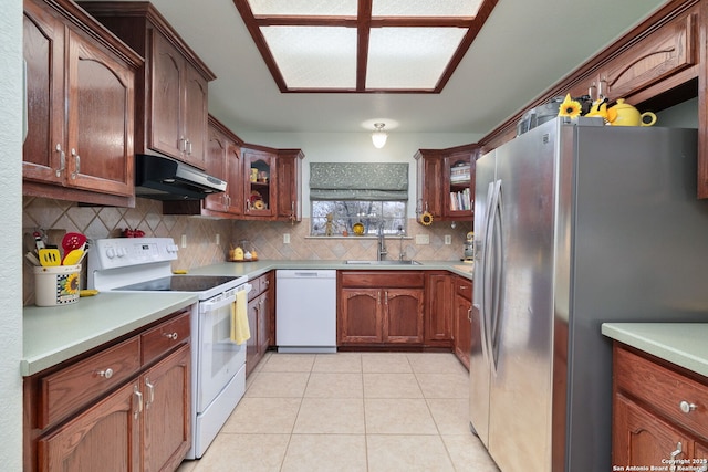 kitchen with decorative backsplash, sink, light tile patterned flooring, and white appliances