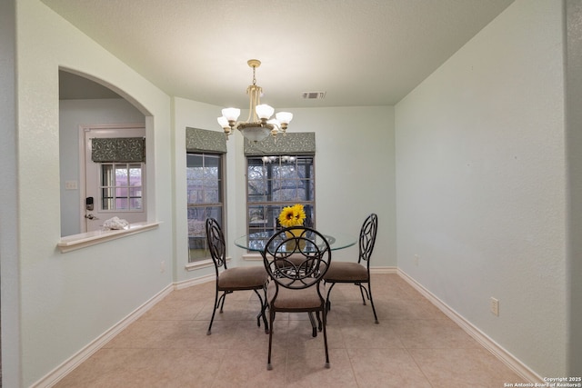 tiled dining space with a notable chandelier