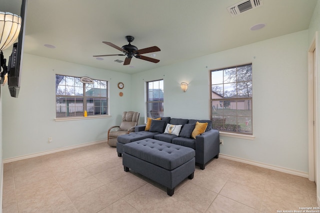 tiled living room with plenty of natural light and ceiling fan