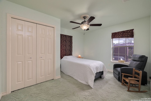 bedroom with ceiling fan, a closet, and light carpet