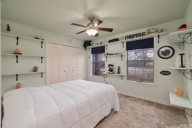 carpeted bedroom featuring ceiling fan and a closet