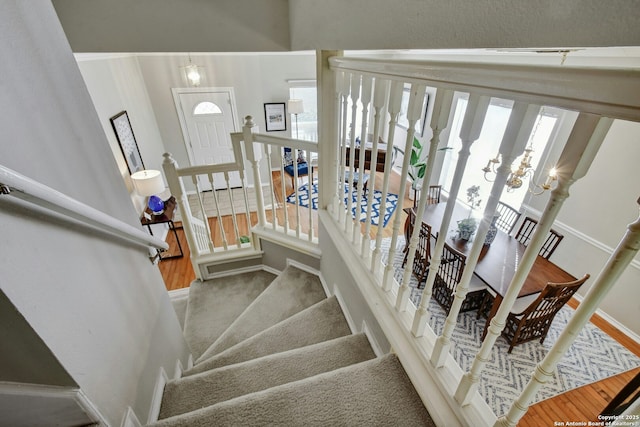 stairway featuring a notable chandelier