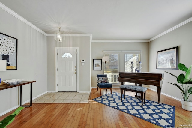 entrance foyer with crown molding, a chandelier, and light hardwood / wood-style floors