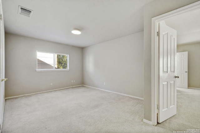 spare room featuring light colored carpet