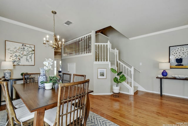 dining space featuring a notable chandelier, crown molding, and wood-type flooring