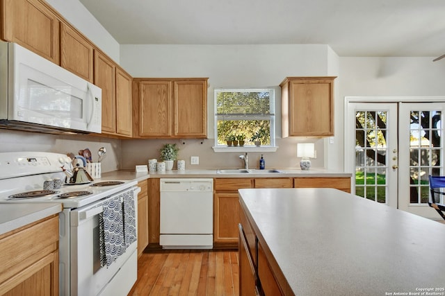 kitchen with sink, white appliances, light hardwood / wood-style floors, and french doors