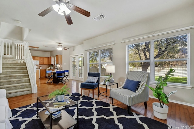 living room featuring french doors, a healthy amount of sunlight, and light hardwood / wood-style flooring