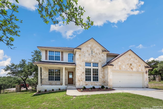 view of front of property with a front yard, a garage, and covered porch