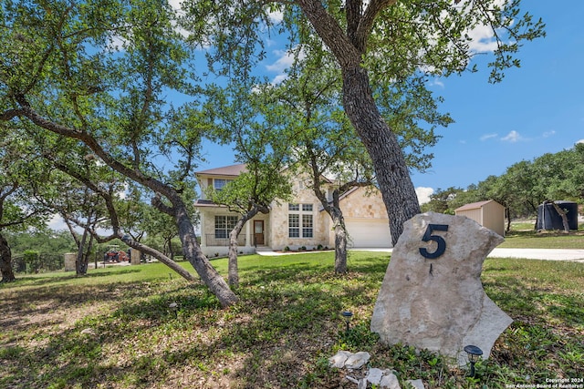 view of front of property featuring a front yard, a garage, and an outdoor structure