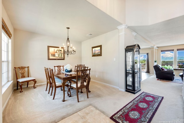 carpeted dining area featuring ornate columns and a chandelier