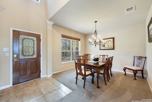 dining area with decorative columns, light colored carpet, and a chandelier