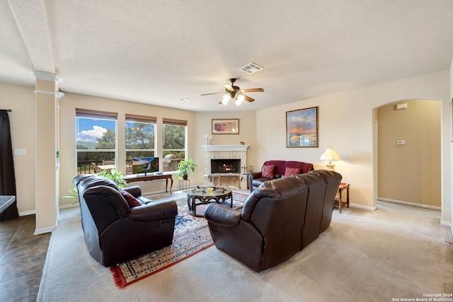 carpeted living room featuring ceiling fan and a textured ceiling