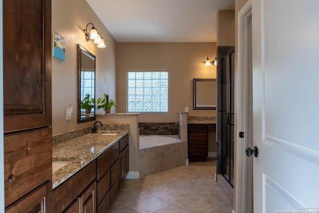 bathroom featuring plus walk in shower, vanity, and tile patterned floors