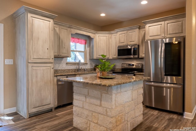 kitchen featuring a center island, stone counters, appliances with stainless steel finishes, tasteful backsplash, and dark hardwood / wood-style flooring