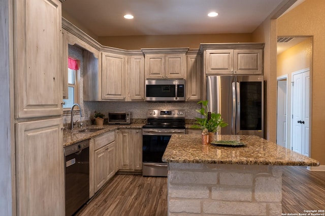 kitchen featuring sink, dark wood-type flooring, stainless steel appliances, light stone counters, and decorative backsplash