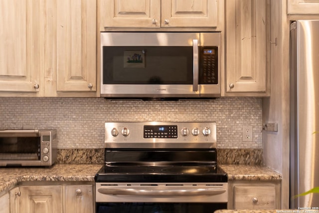 kitchen with stone counters, decorative backsplash, and stainless steel appliances