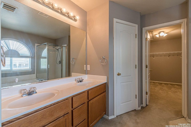 bathroom with vanity and a shower with door