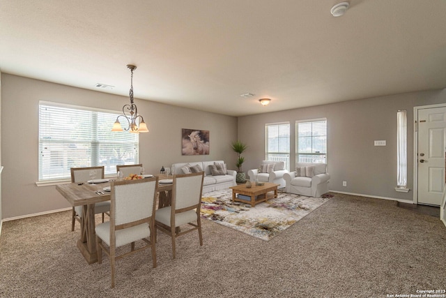 carpeted dining space with a chandelier