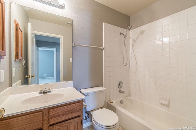 full bathroom with tiled shower / bath combo, vanity, and toilet