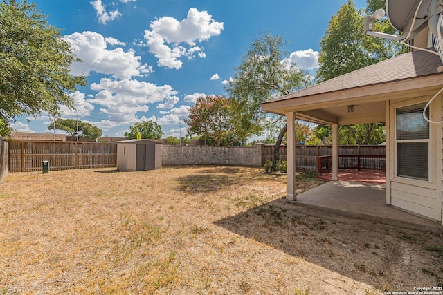 view of yard featuring a storage unit and a patio