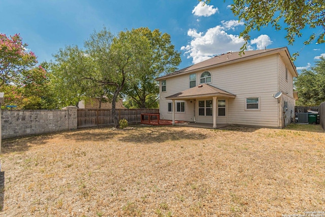 rear view of house with a lawn and central air condition unit