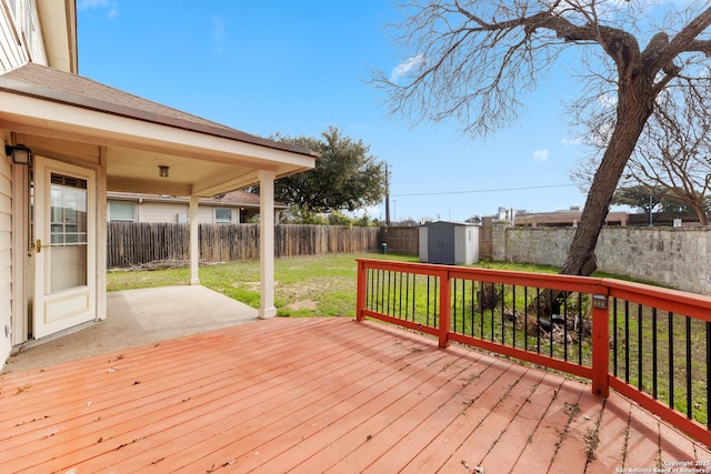 wooden terrace with a lawn and a storage shed