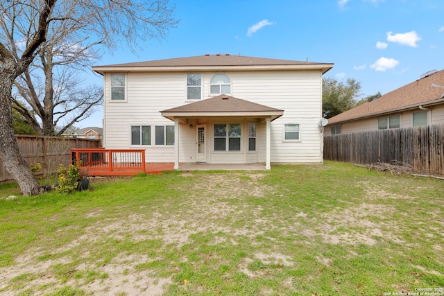 back of house featuring a deck and a lawn