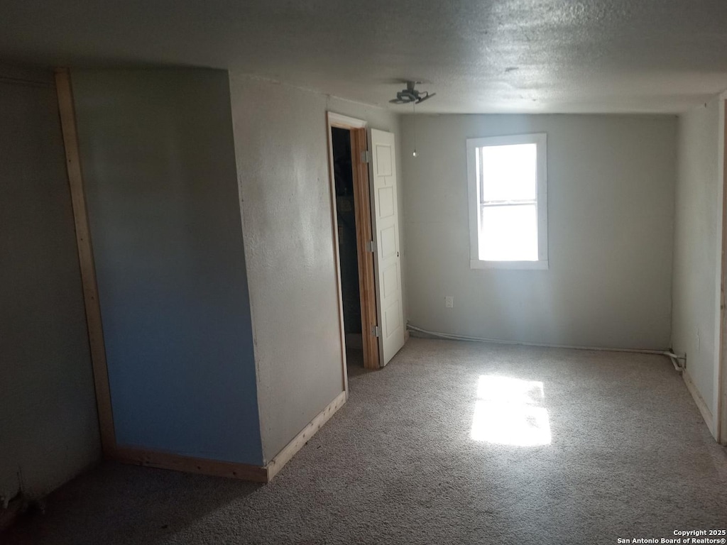 unfurnished room with carpet floors and a textured ceiling