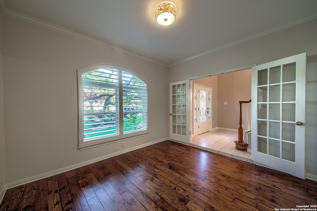 empty room with hardwood / wood-style flooring, crown molding, and french doors