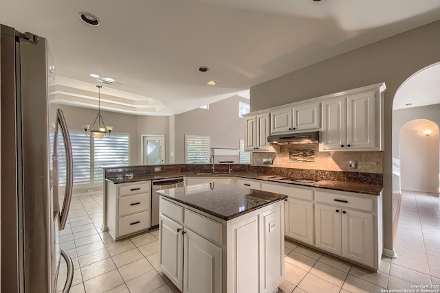 kitchen with sink, stainless steel appliances, a kitchen island, kitchen peninsula, and white cabinets