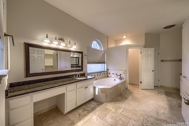 bathroom with vanity and tiled tub