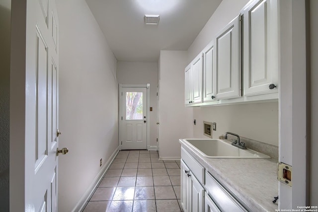 laundry room featuring cabinets, hookup for a washing machine, hookup for an electric dryer, sink, and light tile patterned flooring