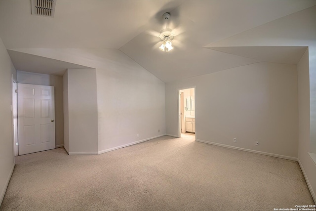 additional living space featuring light colored carpet and vaulted ceiling