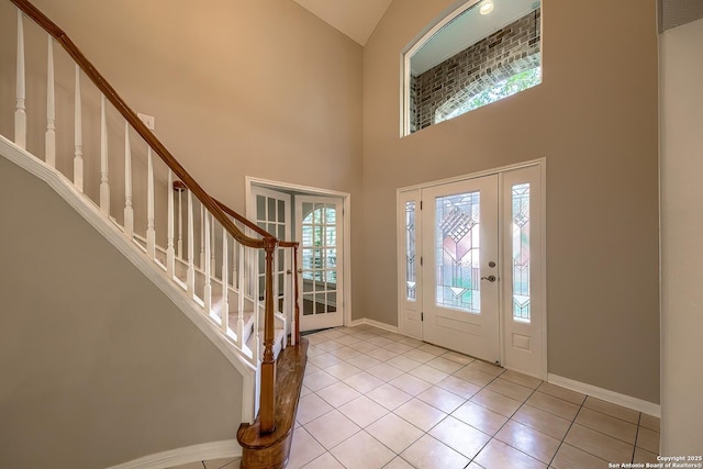 foyer with a towering ceiling and light tile patterned floors