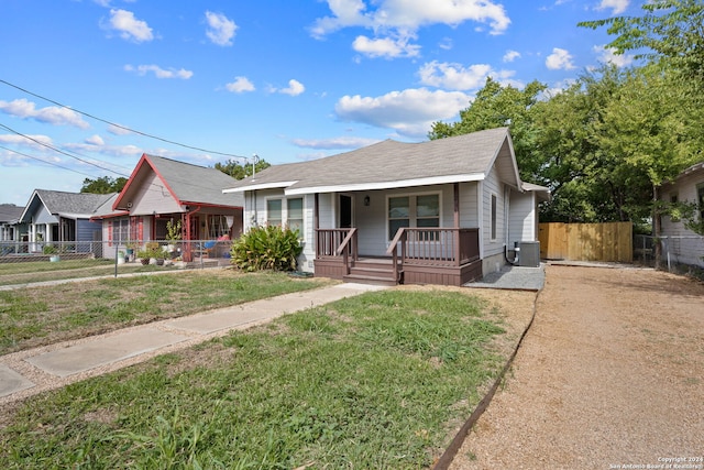 view of front of house featuring central AC unit, a porch, and a front yard