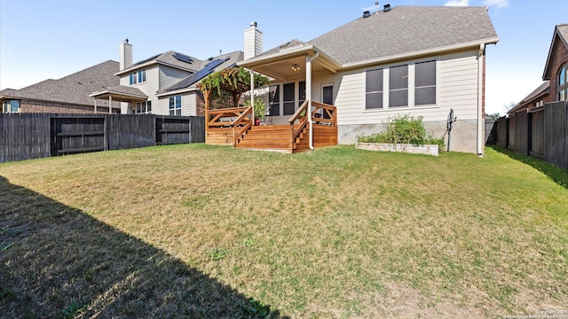 back of property featuring a lawn and a wooden deck