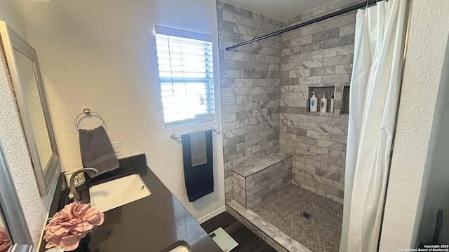 bathroom featuring a healthy amount of sunlight, curtained shower, and sink