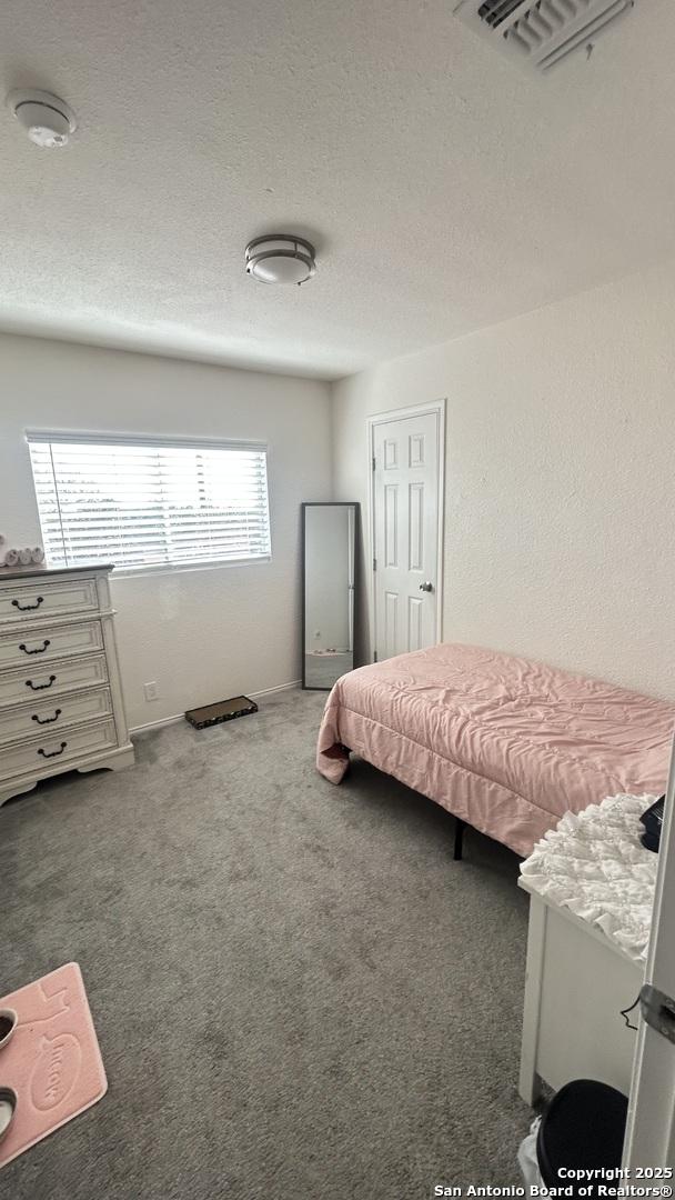 bedroom featuring carpet floors and a textured ceiling