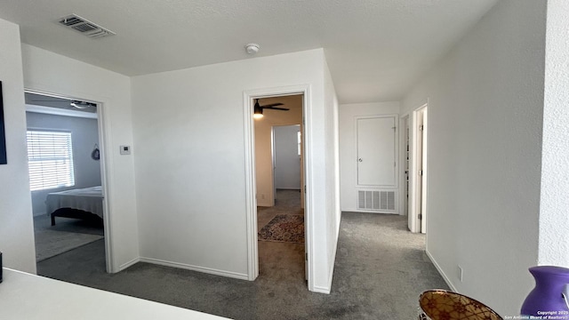 hallway featuring dark colored carpet