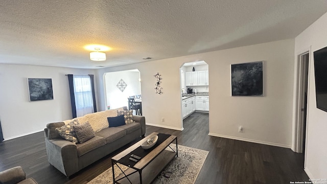 living room featuring dark hardwood / wood-style flooring and a textured ceiling