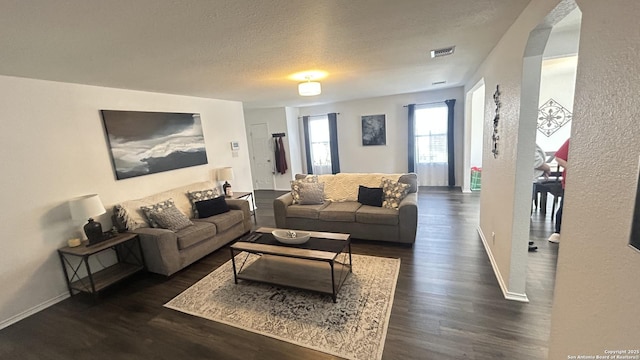 living room featuring dark hardwood / wood-style floors and a textured ceiling