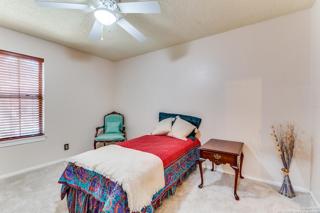 carpeted bedroom with baseboards, a textured ceiling, multiple windows, and ceiling fan