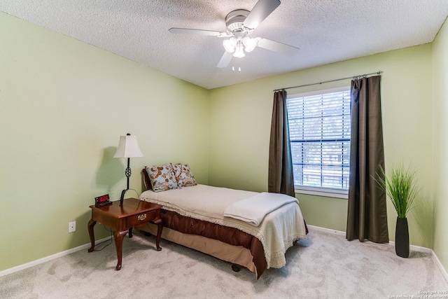 bedroom featuring baseboards, carpet flooring, a textured ceiling, and ceiling fan