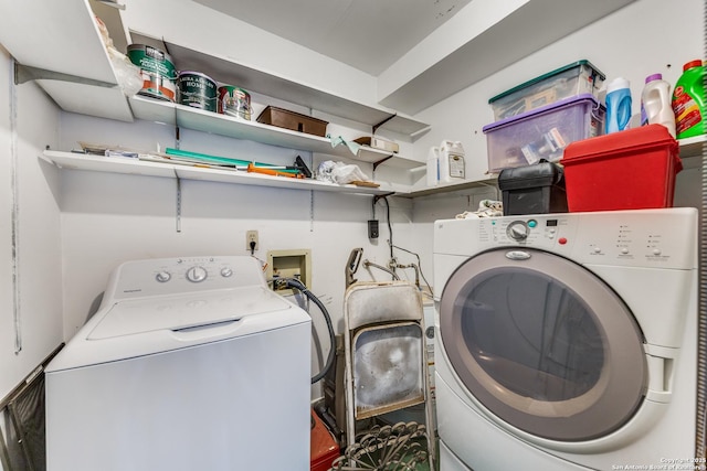 clothes washing area featuring separate washer and dryer and laundry area