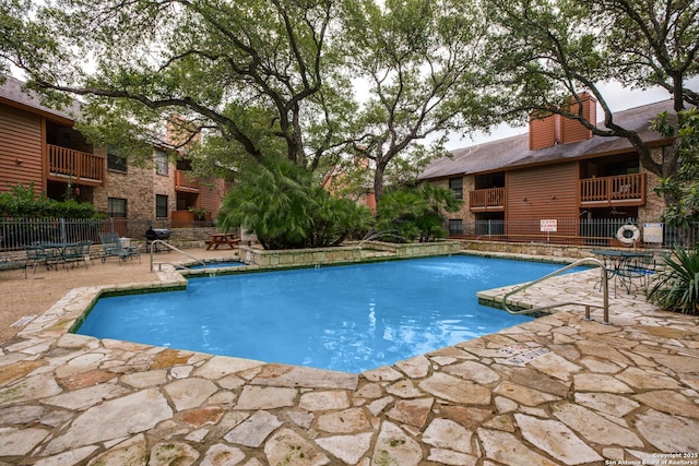 community pool featuring fence and a patio area