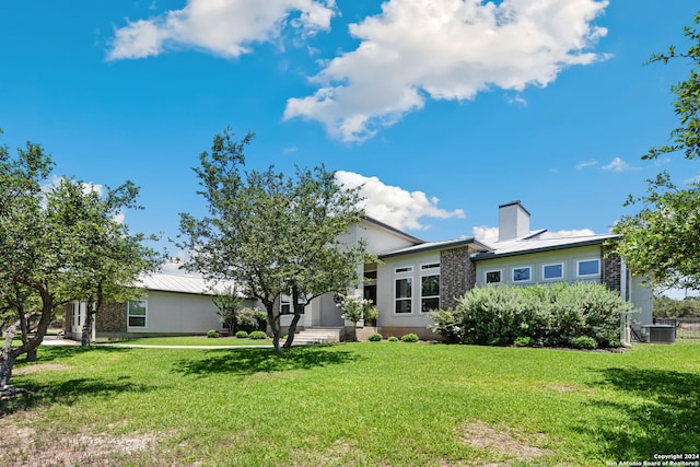 rear view of property with a lawn