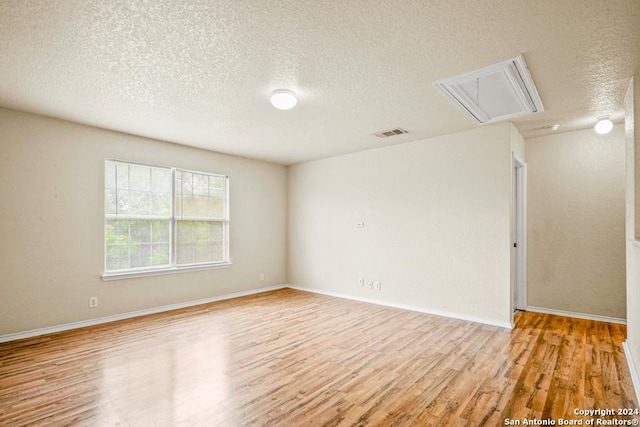 empty room featuring a textured ceiling and light wood-type flooring