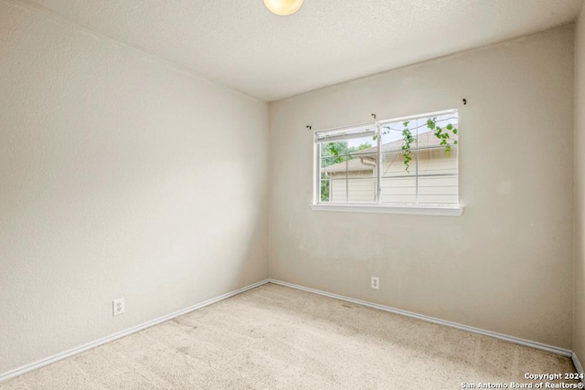 empty room with carpet floors and a textured ceiling